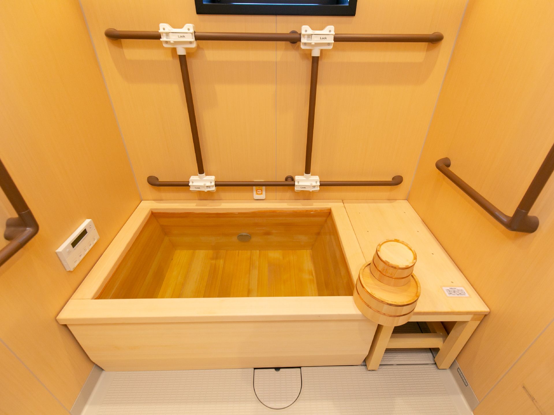 手すりが設置され、転倒防止に配慮された檜風の浴室