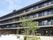 建物前にグリーンを配置した庭が設けられた4階建ての施設外観