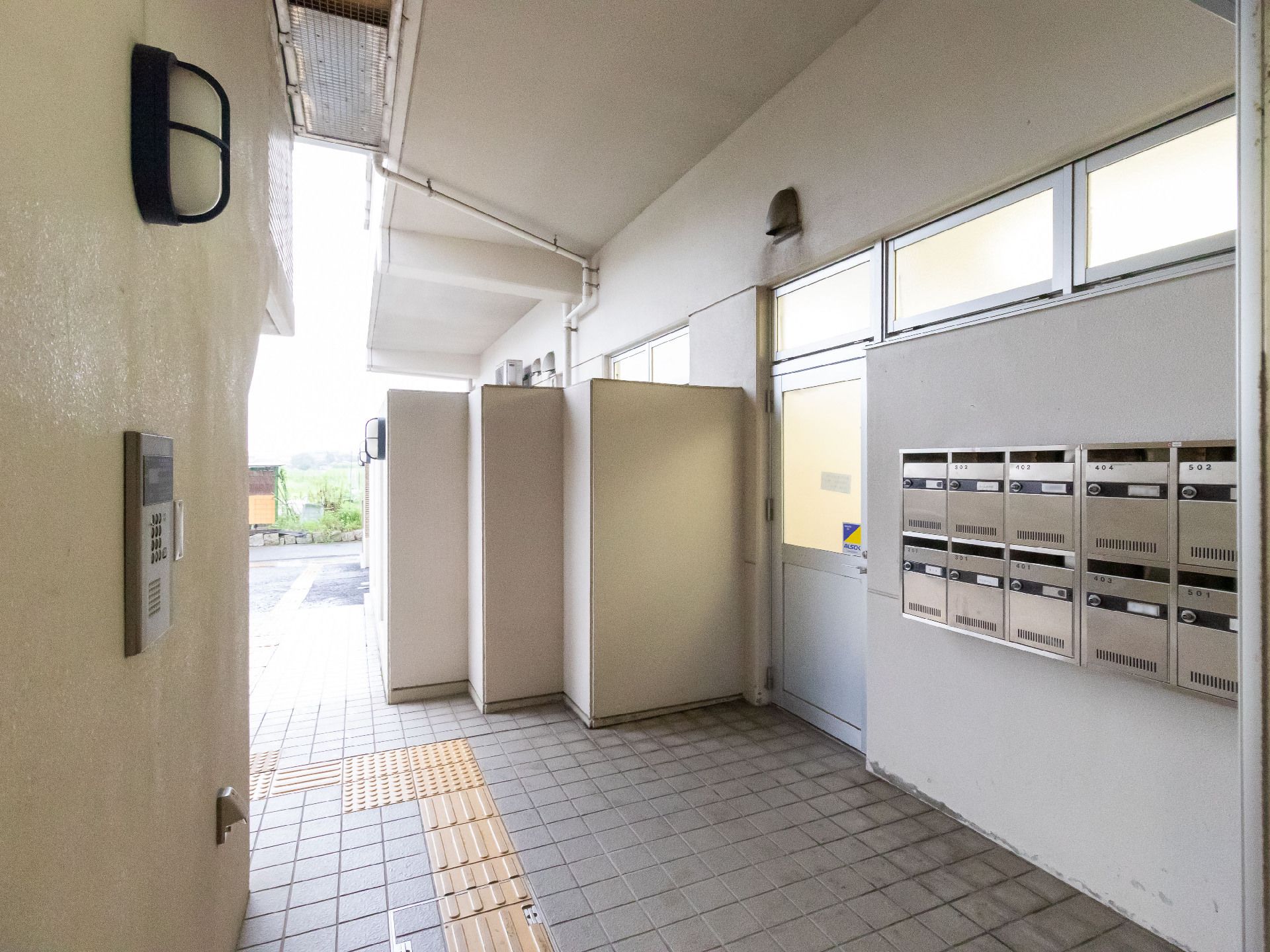 建物の入り口の壁についている銀色の郵便受け