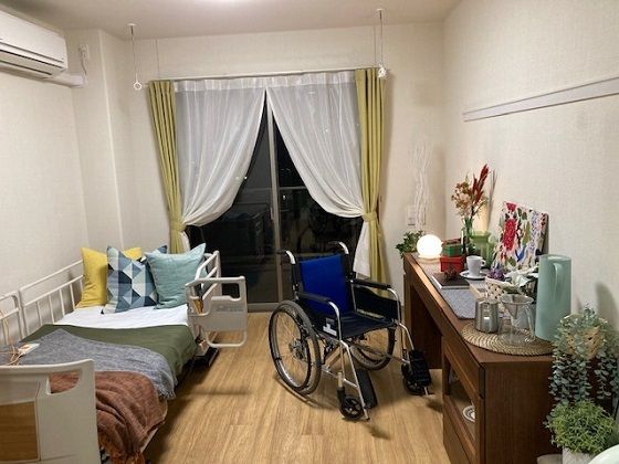 トイレや洗面所が付いた広いフローリングの部屋にはカーテンが付いた大きな窓とエアコンもある。