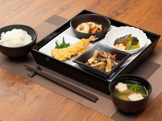 ピンクの椅子がセットされたダイニングテーブルが並ぶ食堂には、テレビもあり明るい雰囲気。