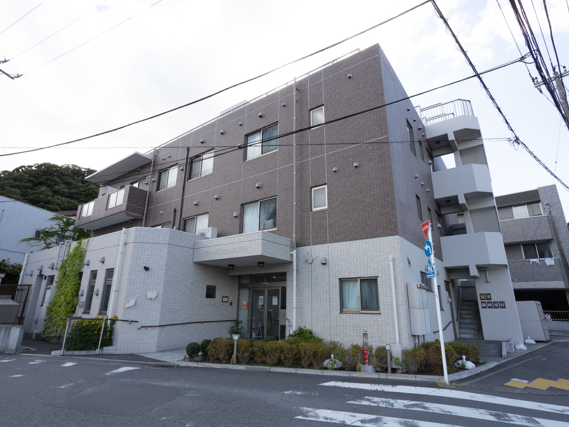 赤い車椅子に座っている高齢女性と笑顔で介助をする女性ヘルパー