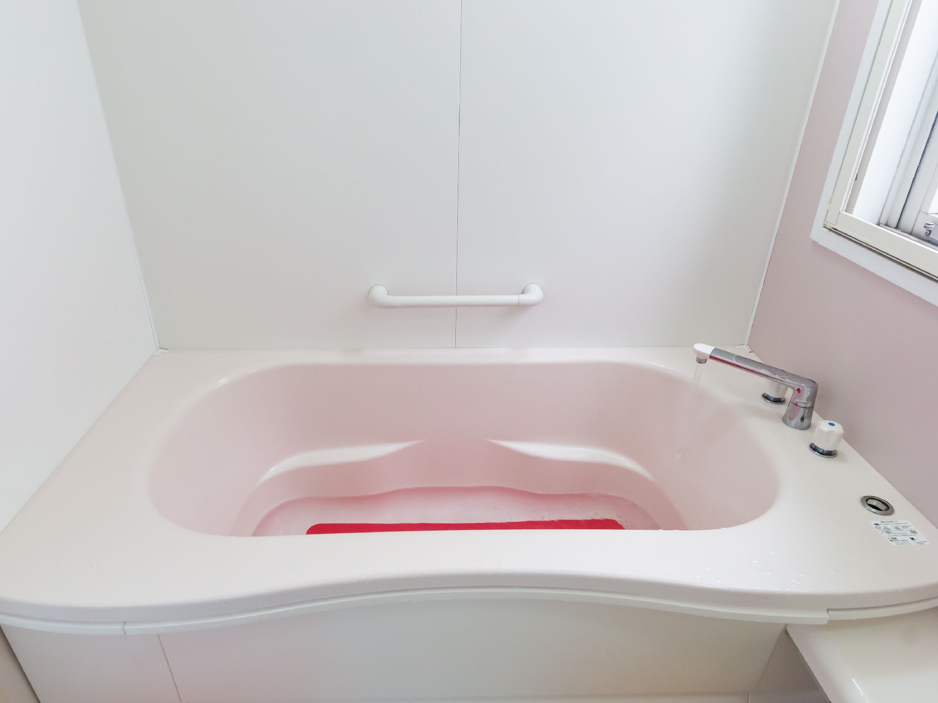 手すりが多数取り付けられ、滑りにくい床材が使用されている浴室