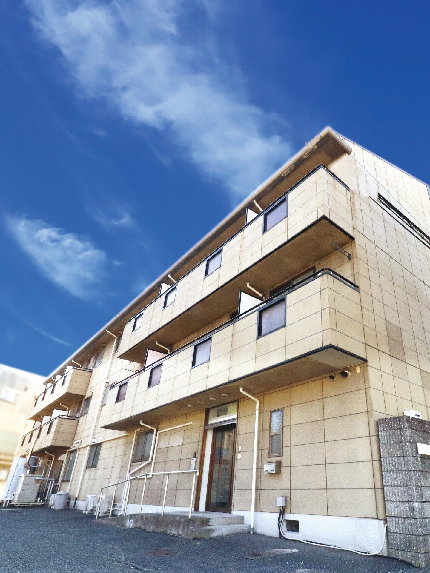 各フロアにベランダがあり、建物周辺にはものがなく、玄関には手すり付きのスロープがある。3階建てでスタイリッシュなデザイン。