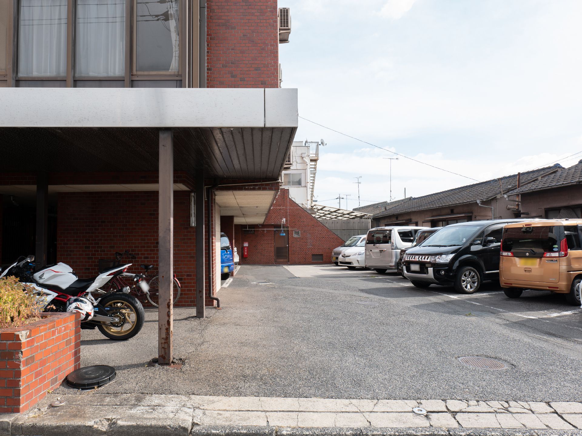バイクと車が停まっている様子の外観