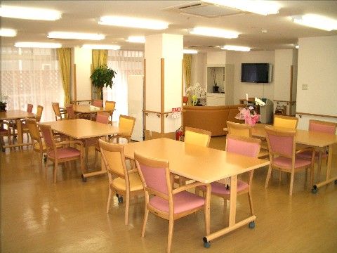 ベージュ系を基調とし、4人掛けのテーブルが複数配置された食堂