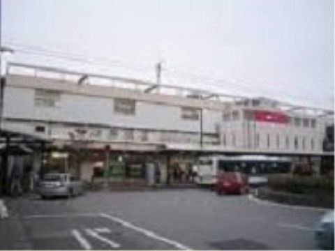 駅の建物の外観である。建物の壁は白色基調で、駅の前はロータリーになっており自家用車やバスが移動している。