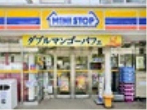 施設近隣のコンビニエンスストアの正面の入口周辺である。自動のガラス引き戸の上の壁面には店名が表示されている。