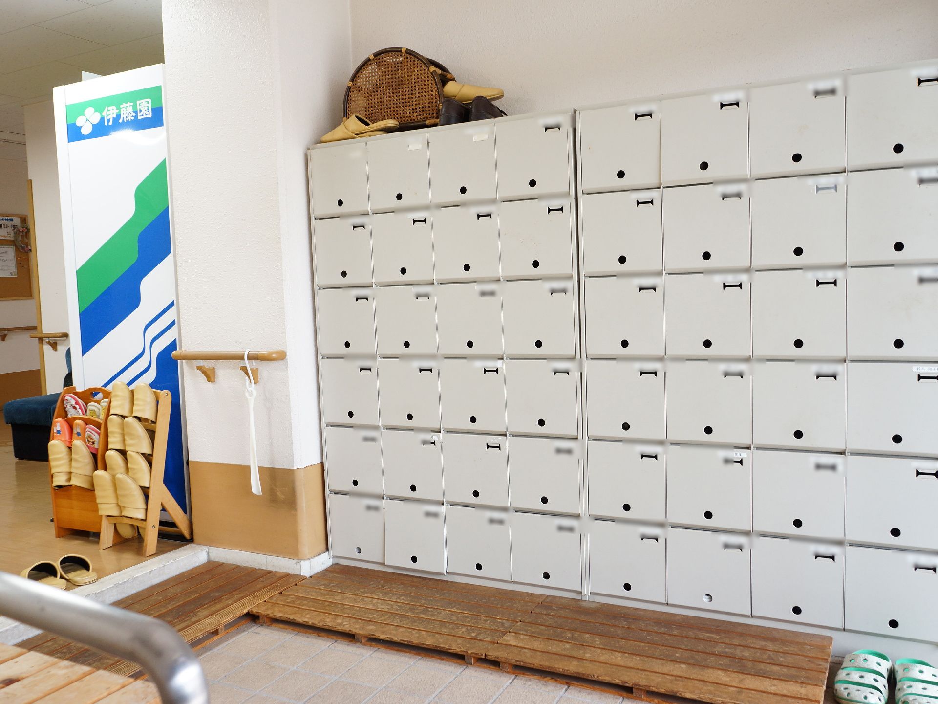 大型の靴箱の写真。グレーでとても大きい。横に4足、縦に6足入るものが、2台並べて置かれている。その前にはすのこが敷かれている。