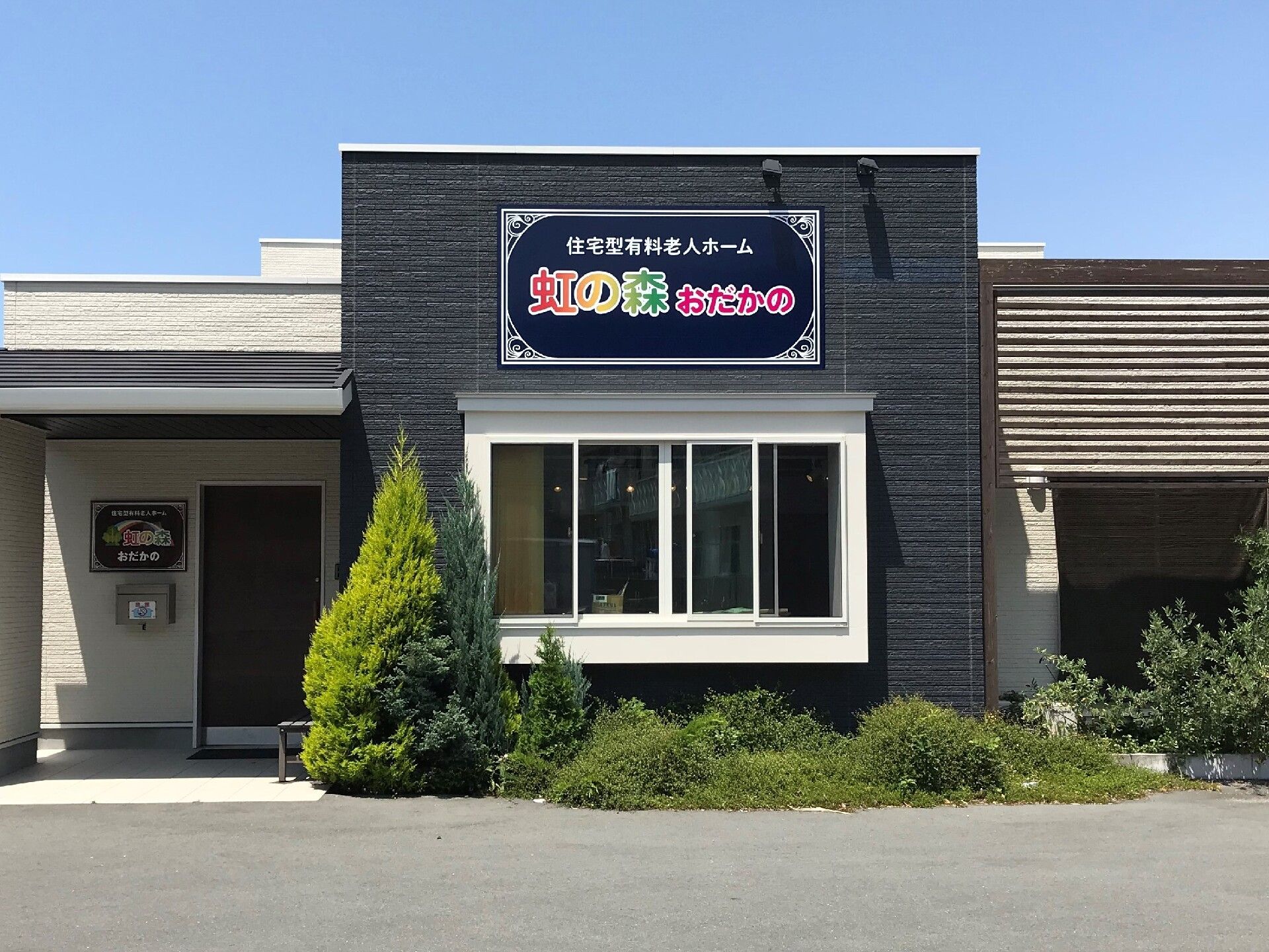 虹の森の看板が色鮮やかに掲げられている施設の外観写真。高齢者向け施設の外観