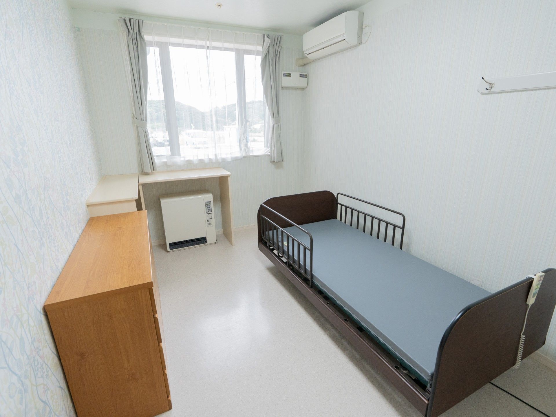 窓際のベッドと机の部屋