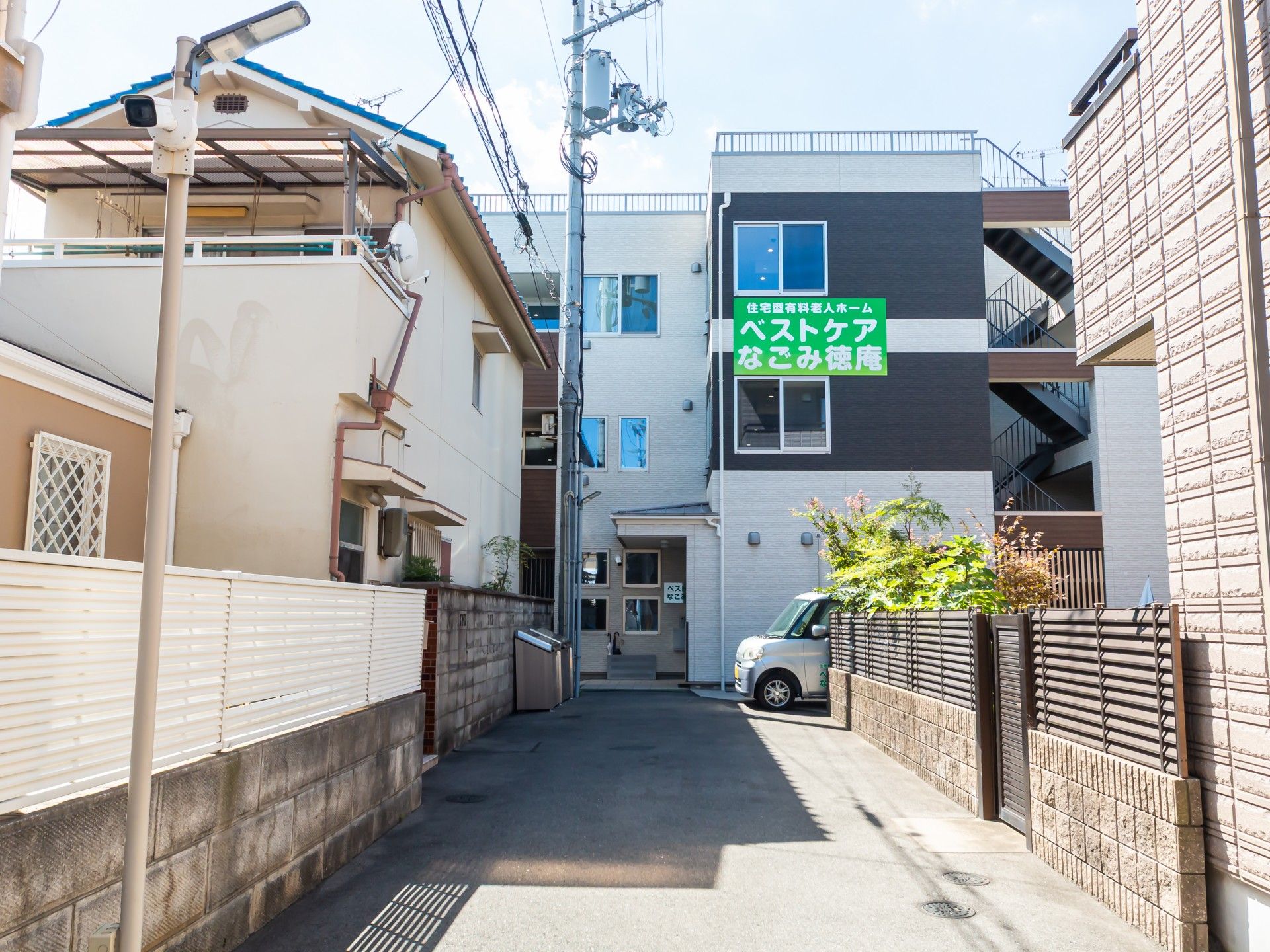 なにかを指さして笑顔で話している車いすの女性とそれを押している介護スタッフの様子