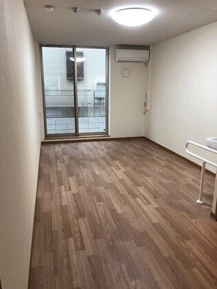 大きな窓があり外につながっている部屋。エアコンがついたワンルーム