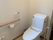 スライド式のドアが付いたトイレは広く、壁にはトイレットペーパーホルダーと手すりが付いている。手すりの上には操作パネルもある。