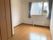 大きな窓にはカーテンが付き、窓の下にはパネルヒーターも付いている。フローリングの部屋は家具や家電は置かれていない。