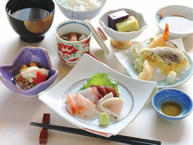 グリル野菜が添えられたステーキや刺身が乗ったサラダ、いちごソースがかかったデザートなどが並んでいる。