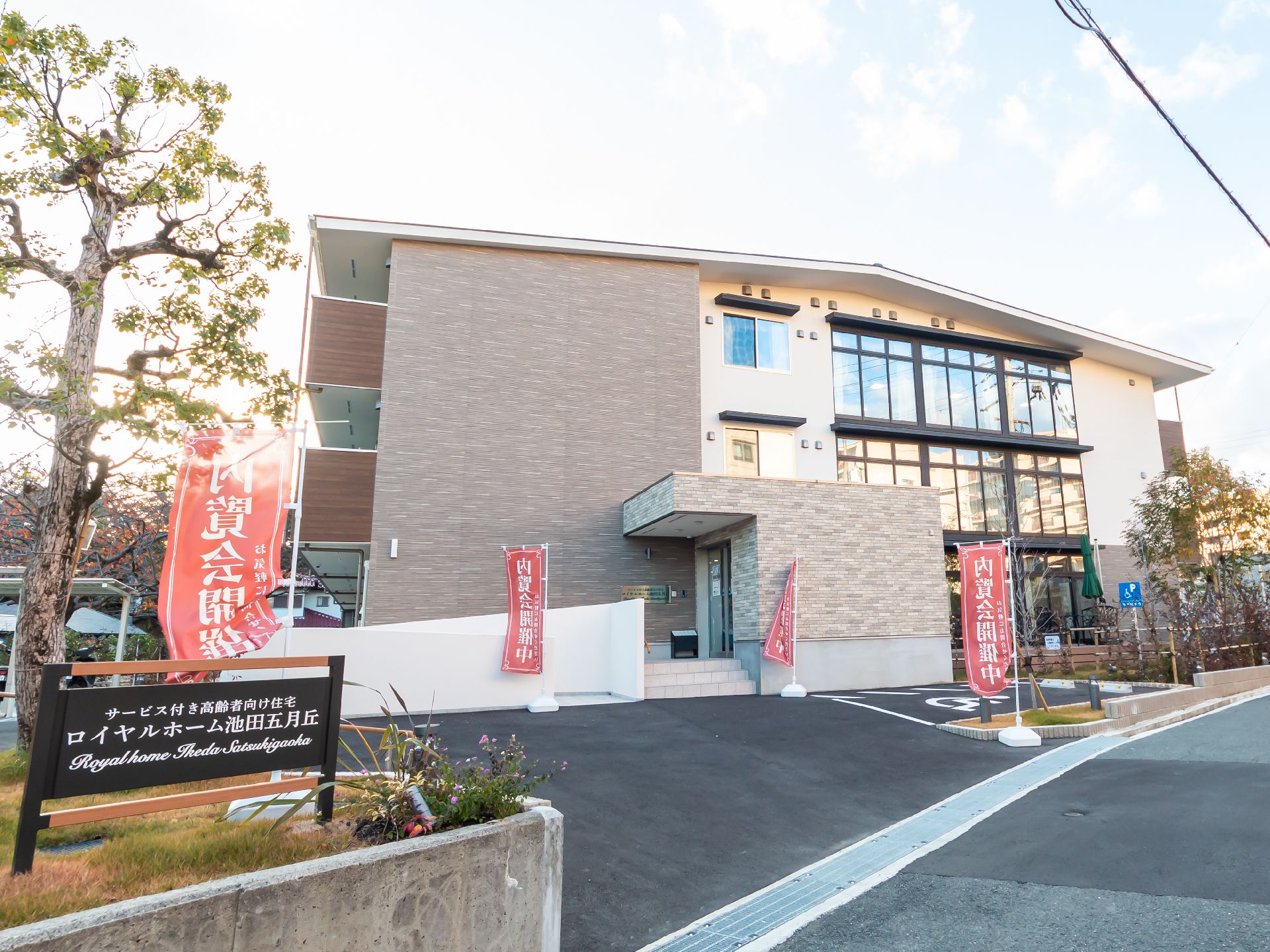 ３階建ての建物。ブラウンを基調とし、敷地内には駐車場があり、ベランダが付いている。