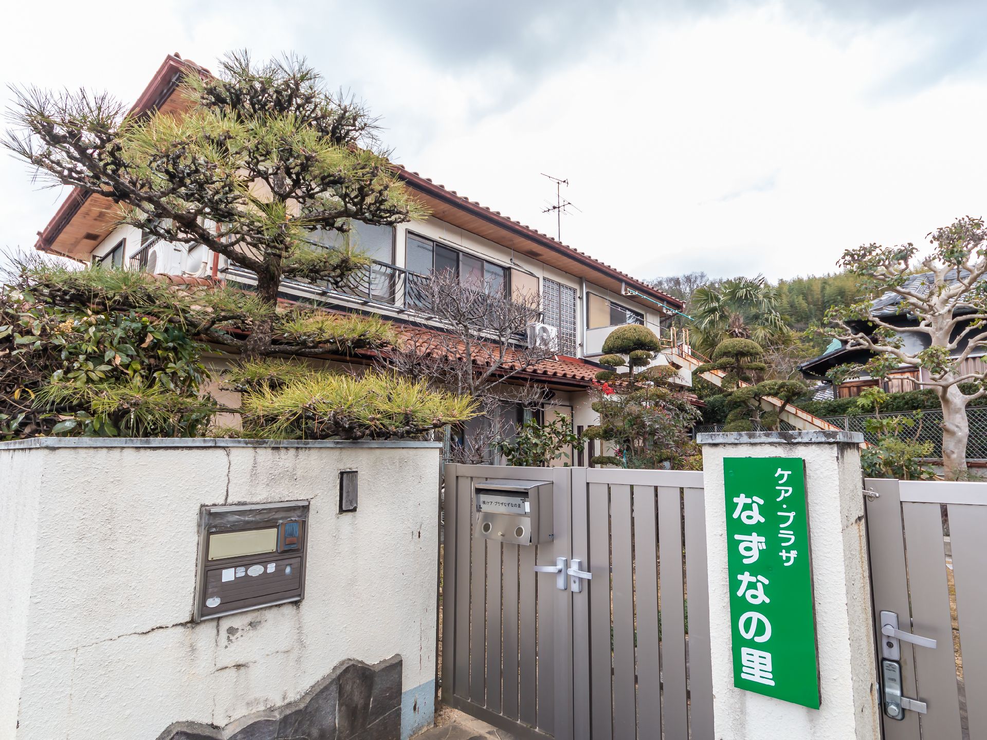 緑の看板が設置されたグループホームの外観