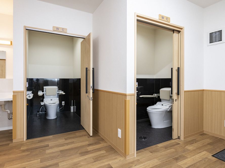 手すりや背もたれが付いた広いトイレが２つあり、それぞれに大きなドアが付いている。
