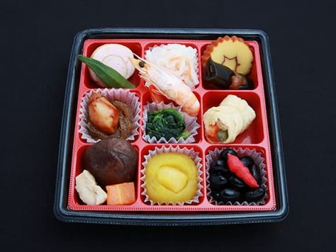 野菜の煮物や厚焼き玉子、海老や栗きんとんの盛り付けられたおせち料理