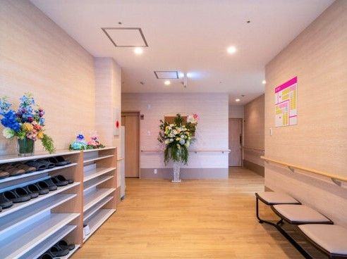 花や下駄箱がある施設内の共有スペース。エントランスに近い場所