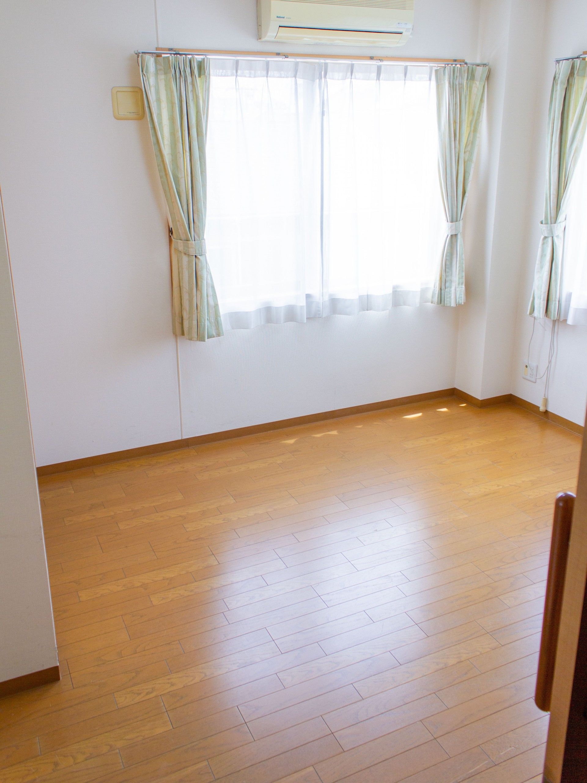 手を叩いて笑う高齢女性と女性スタッフ