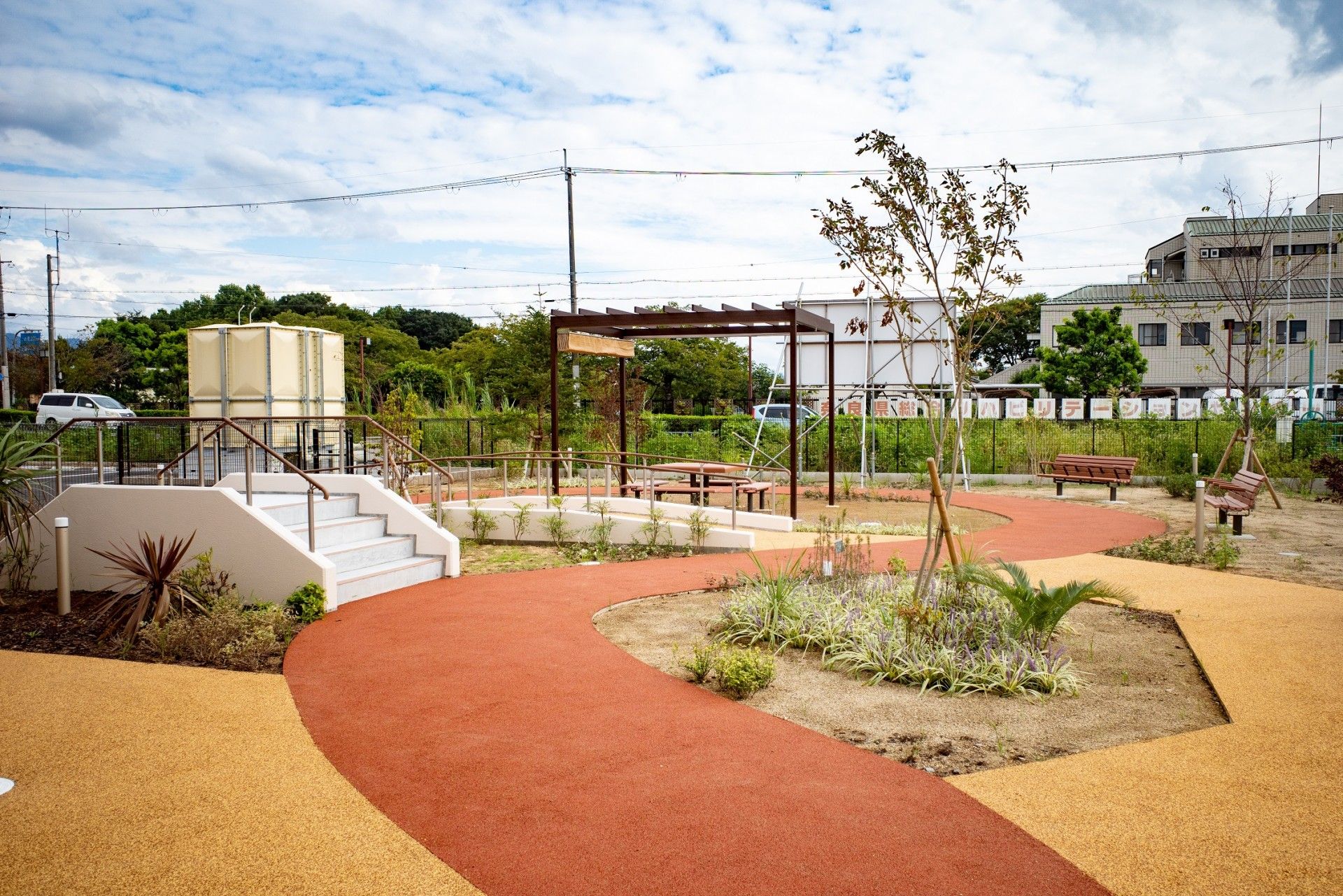 水の入ったコップをもってほほえむエプロンを付けた女性スタッフ。そばには薬を飲もうとしている高齢女性がいる。