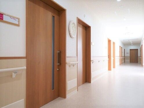 幅の広い廊下には通行の妨げになるようなものはなく、居室のドアは大きなスライドドアで、表札がかかっている。
