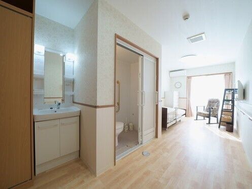 日当たりのいい個室にはトイレや洗面所、クローゼットが付き、寝具付きのベッドが窓の近くにある。