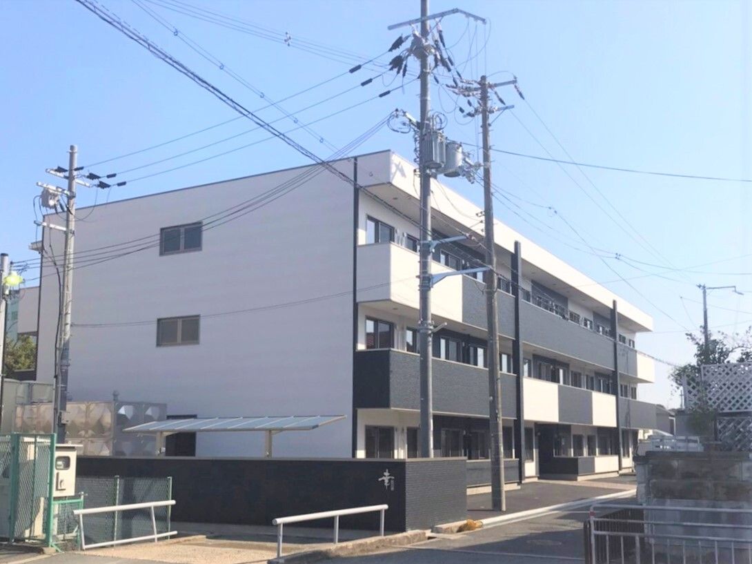 白と黒を基調としモダンな雰囲気がある3階建ての施設外観