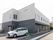 ツートーンカラーの建物と車の停まっている駐車場