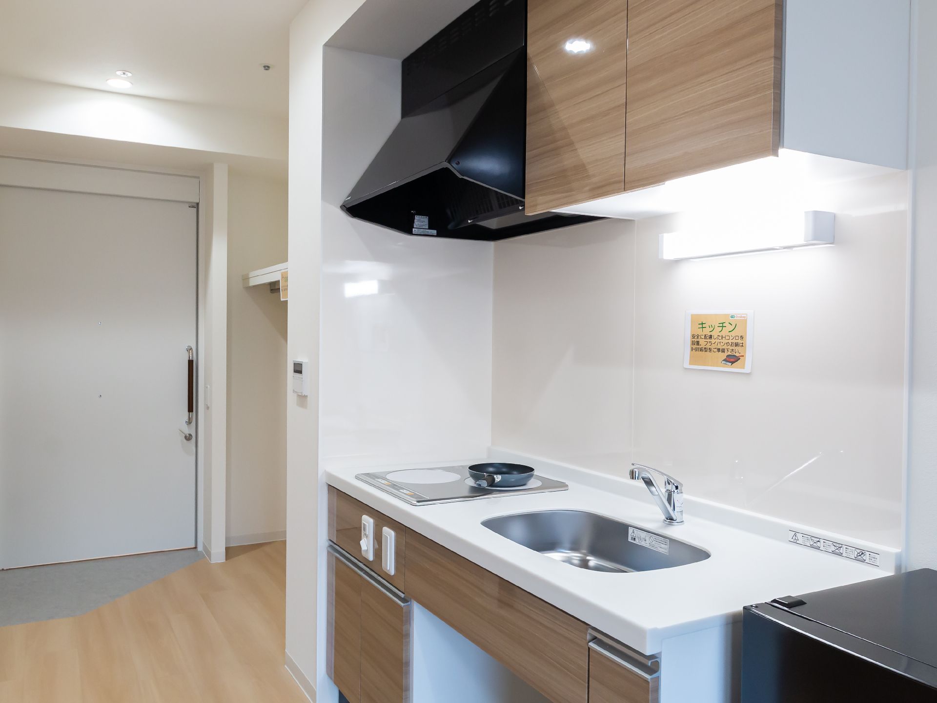 日差しのさす、手すりが設置されたスペースのある廊下