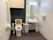 手すりがついたトイレと洗面台がある施設内のトイレの様子。