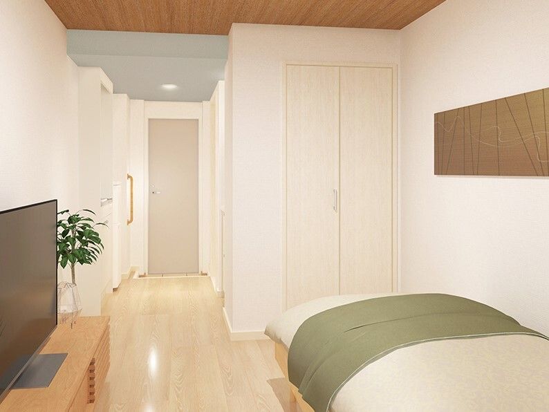 ベッドやテレビを設置したシンプルな部屋。キッチンや収納があり観葉植物も飾られている。