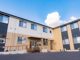 白と黄色と紺の２階建ての建物