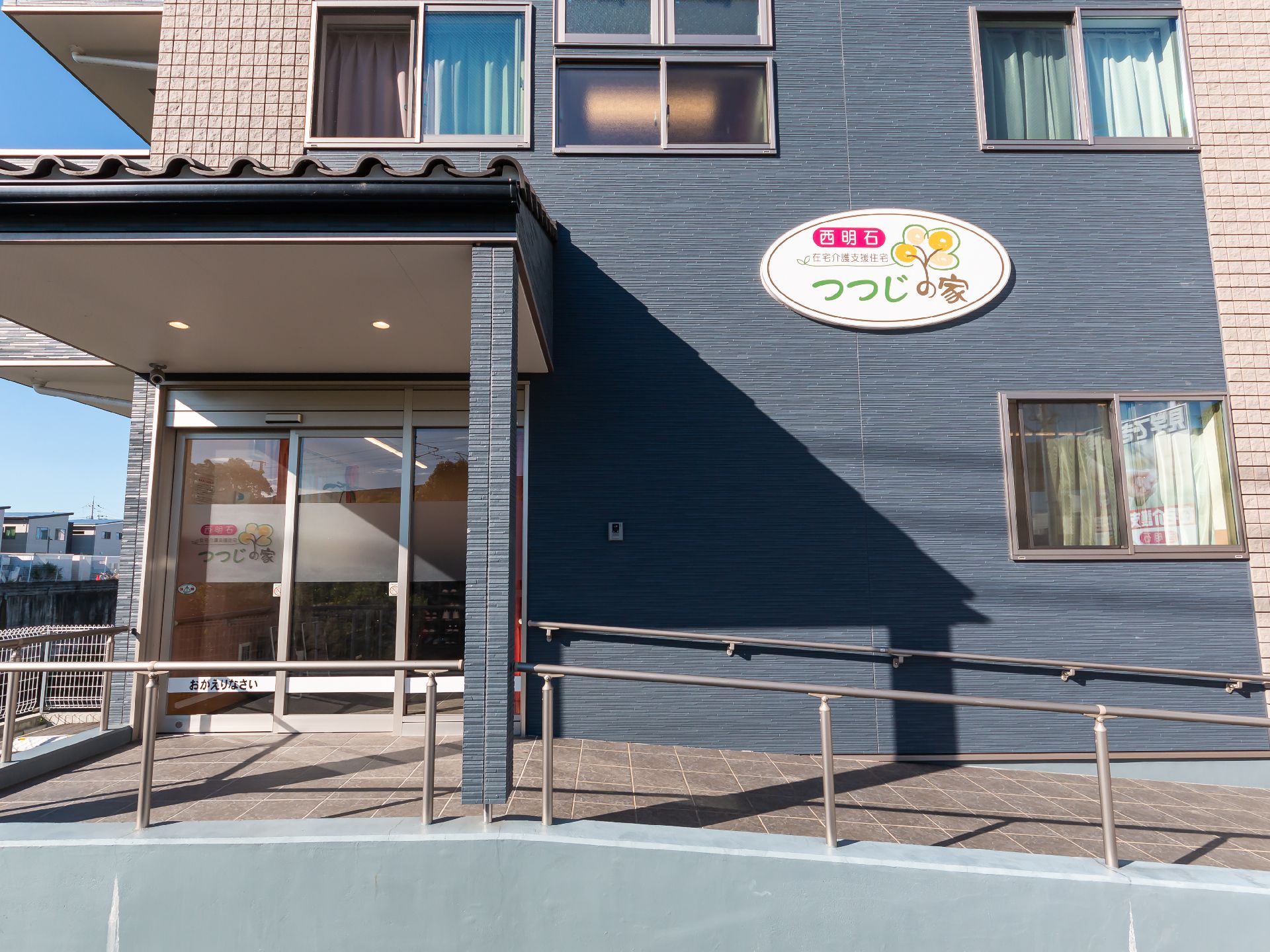 黒い外観の建物のスロープが付いている入り口