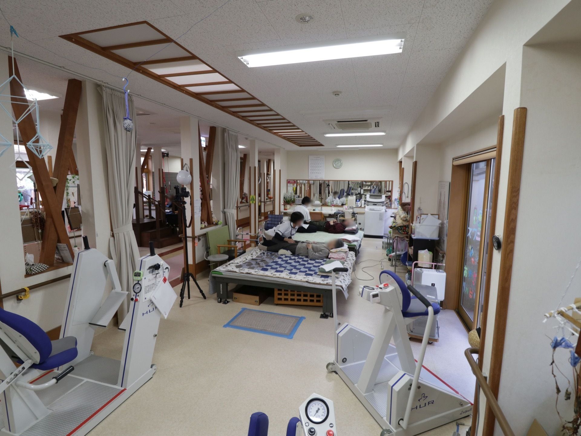 広々とした機能訓練室である。リハビリマシーンや訓練台が完備されている。奥には、洗面スペースが設けられている。
