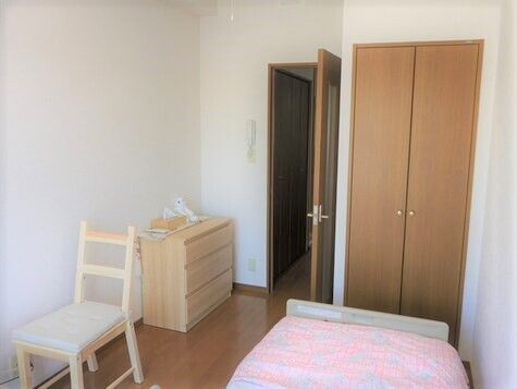 タンスやいす、ベッドや収納がある小さなワンルームタイプの部屋