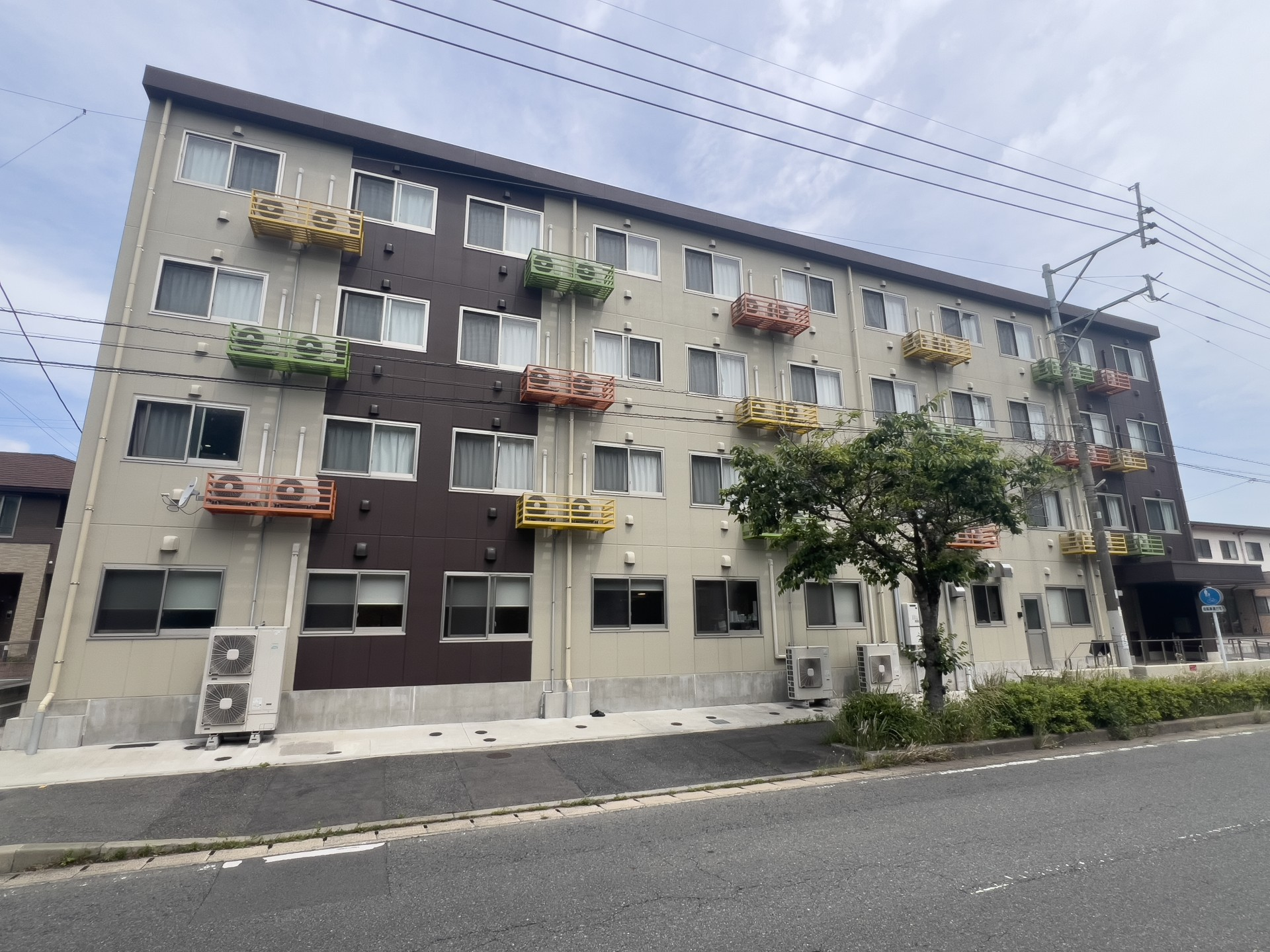 ベージュと濃茶、ツートンカラーの外壁の4階建て老人ホーム