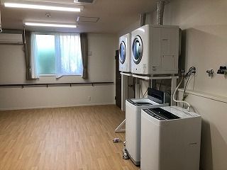 縦型の洗濯機が二台置かれたフローリングのスペースは広く、洗濯機の上に乾燥機も設置されている。