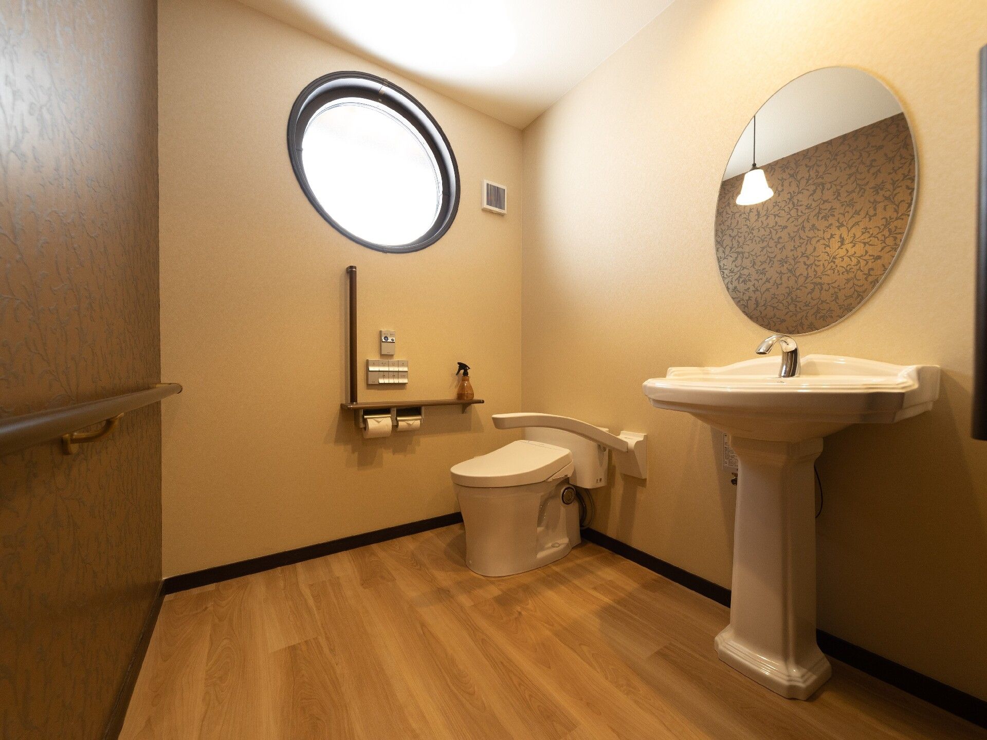 円形の窓が付いたトイレは広く、洗面所にも円形の鏡が付いている。トイレットペーパーホルダーや呼び出しボタン、エル字型の手すりが壁についている。