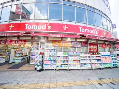 Tomo’ｓと書かれた赤でまとめられた店舗。店の前にはたくさんの商品が並んでいる。