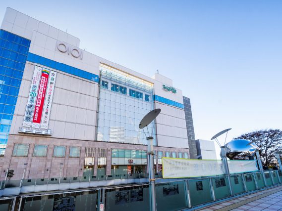 ブルーと白の外観の大きな建物の上には〇I〇Iと書かれている。お勧めのイベントなどの垂れ幕もかかっている。