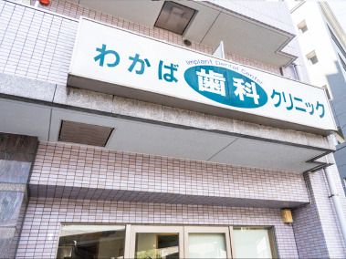 「わかば歯科クリニック」と書かれた大きな白い看板が設置されているレンガ調の外壁の建物。