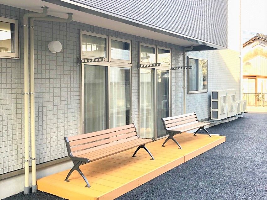 屋外の洗濯物干し場の下には小さなテラスのようなスペースがあり、木製のベンチが二つ置かれている。2階のベランダが屋根のようになっている。