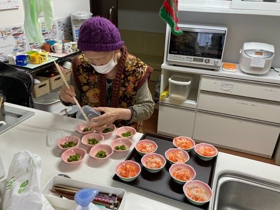 桜の壁画が飾られたリビングダイニング。手前にはダイニングテーブルが置かれ、奥にはソファとテレビが置かれたスペースがあり、家具は暖色系でまとめられている。