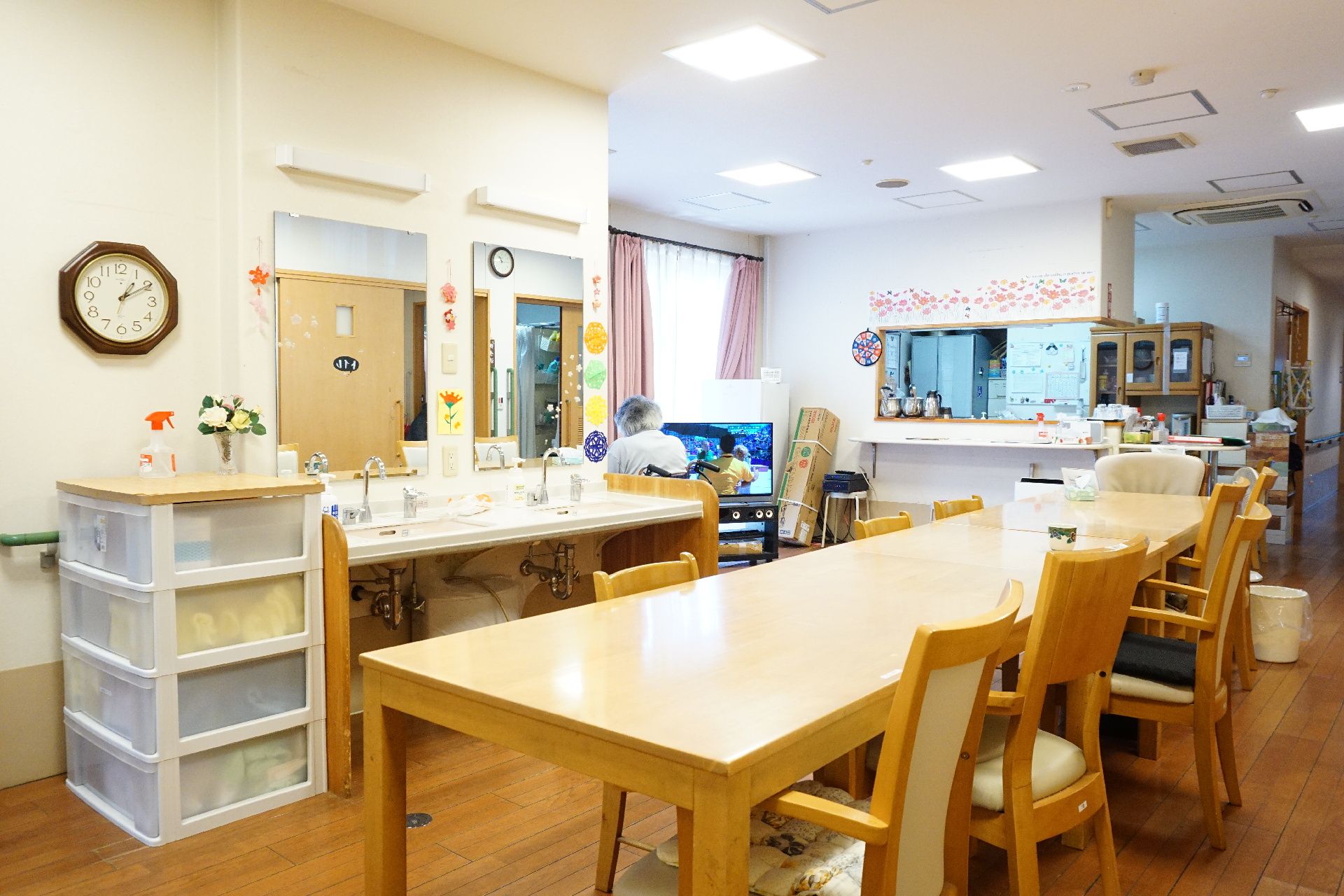 洗面台が設置され、収納やテーブル、椅子が置かれているリビング