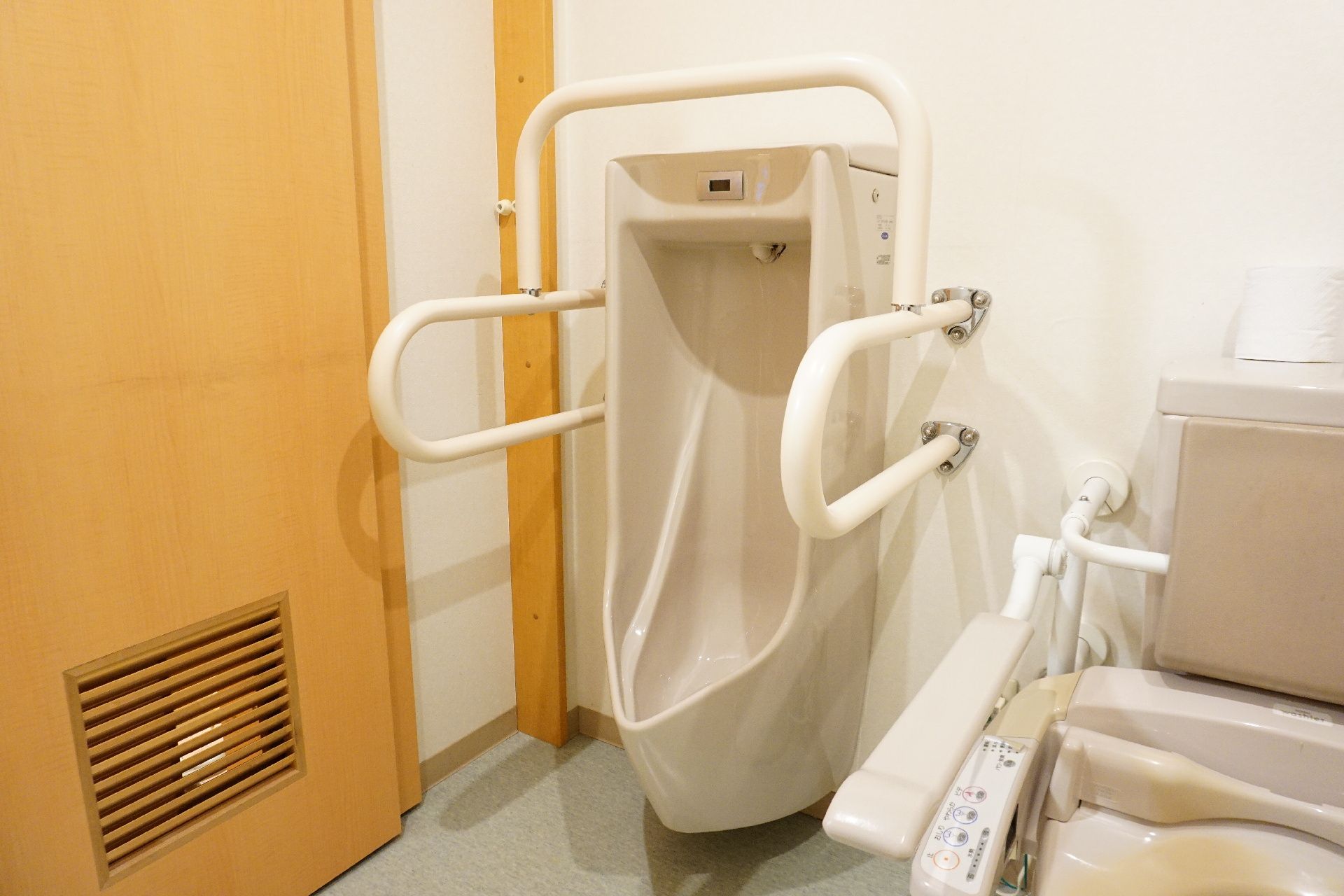 男性用の便器周りに設置された転倒防止のための手すり