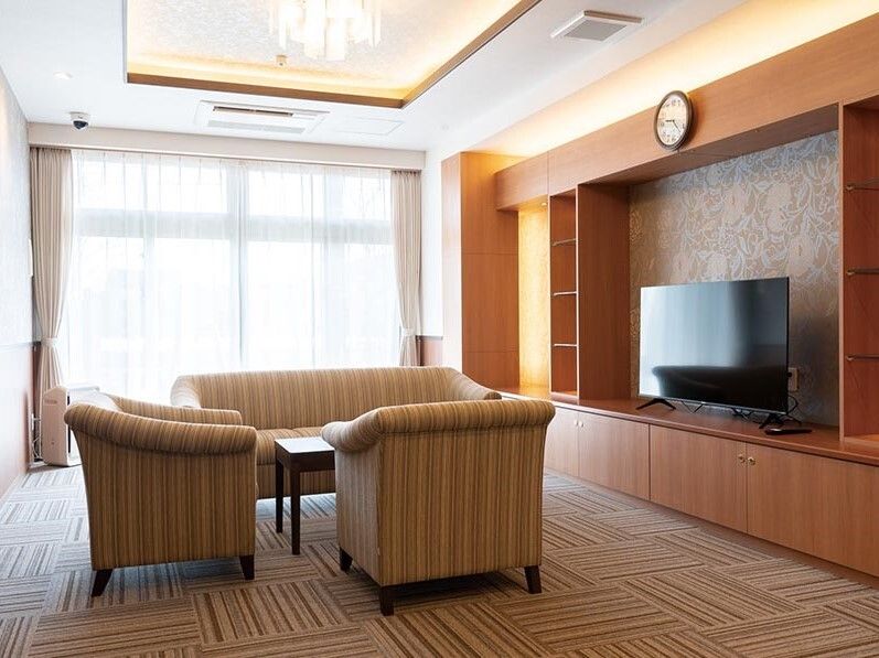 大きなテレビが設置されたスペースにはストライプ柄のソファが設置された応接セットが置かれ、日当たりもよい。