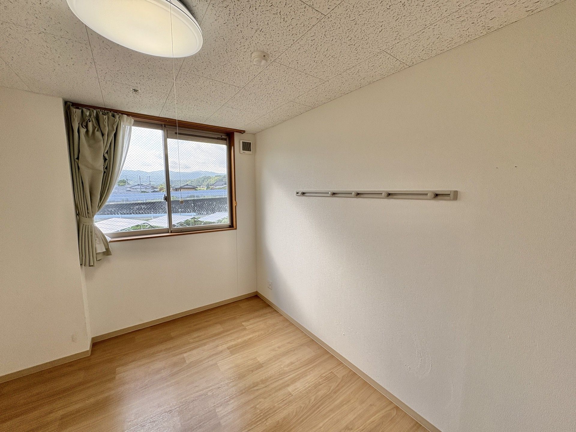 自然の中を散歩する車椅子に乗った高齢女性と介助をする女性ヘルパー